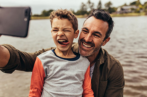 Father & son taking smiling selfie