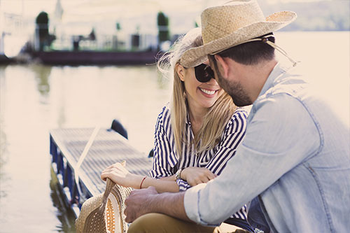Couple smiling by the lakeside dock